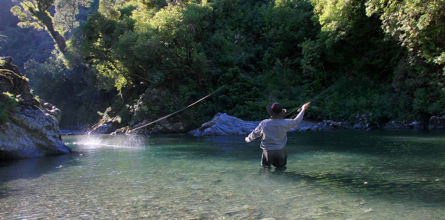 fly fisherman strikiing while fishing New Zealand backcountry river><br>
 
  <a href=