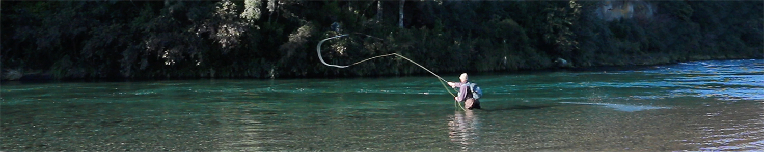 Fisherman spey casting into long emerald pool on river